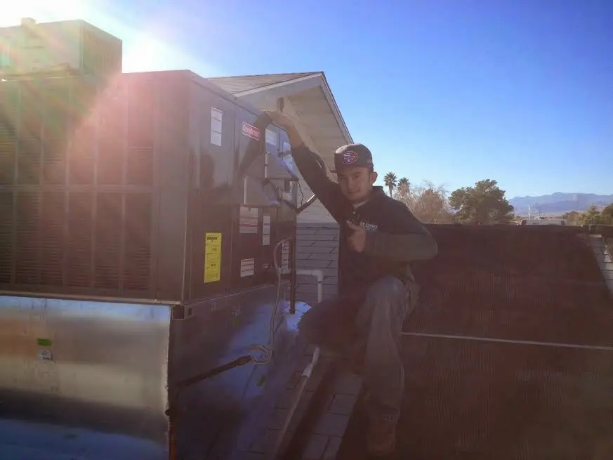 HVAC technician performing AC Tune-Up on a rooftop unit in LaSalle